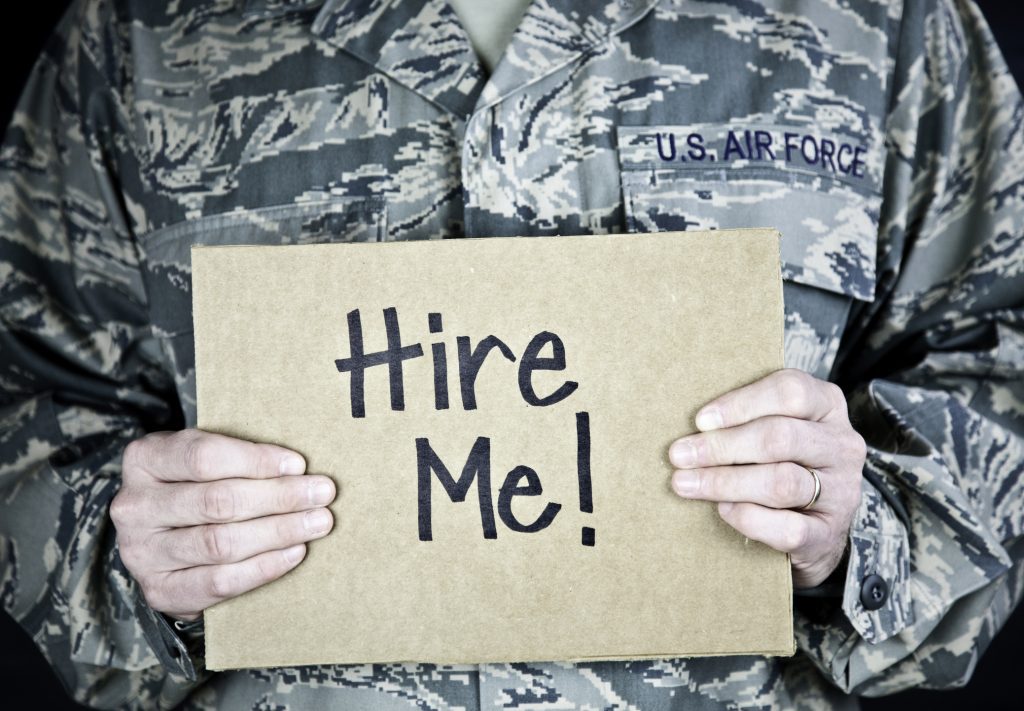 U.S. soldier holding a "hire me" sign
