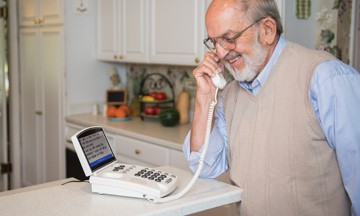 Senior man using Captioned Telephone